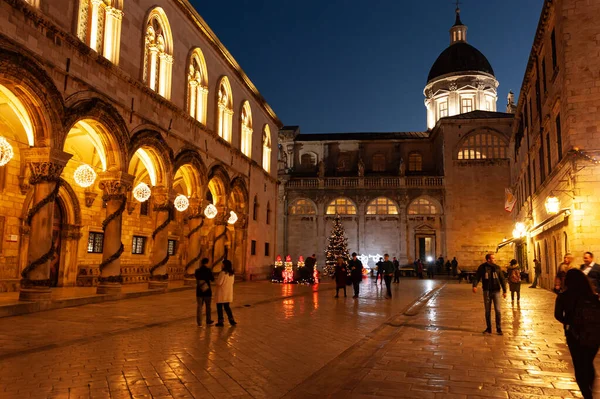Dubrovnik Rektör Sarayı ve Katedral Kubbesi ile sokak sahnesi. İnsanlar Noel zamanı geceleri gezinirler. 
