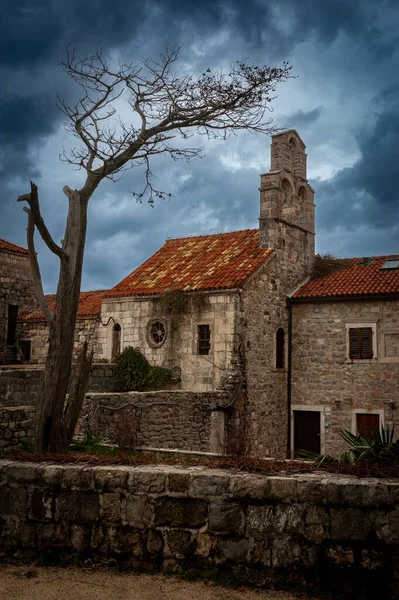 Punta Kilisesi 'ndeki Santa Maria Eski Budva, Karadağ Korkunç Ağacı ve Kara Uğursuz Bulutları ile