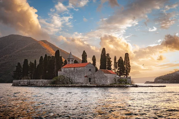 Perast Montenegro yakınlarındaki Kotor Körfezi 'ndeki St. George adasındaki ortaçağ Benedikt manastırında (Sveti Corce) muhteşem bir gün batımı yaşanıyor.