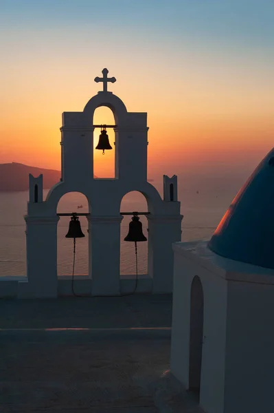 Aziz Gerasimos Kilisesi 'nin çanlarıyla Yunan adası Santorini' de muhteşem bir günbatımı. Santorini 'deki en çok fotoğraflanmış kilise.