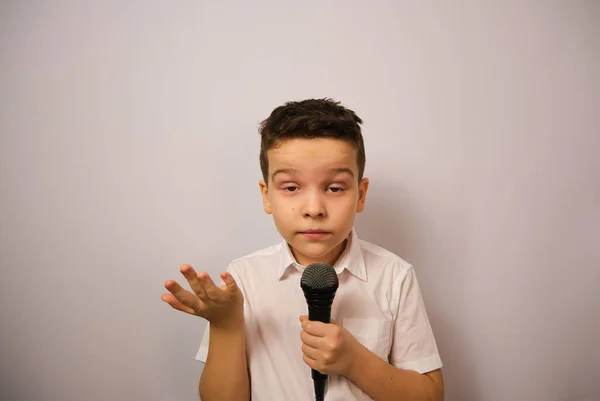 Ein Junge Mit Mikrofon Auf Weißem Grund Weißen Hemd Zeigt — Stockfoto