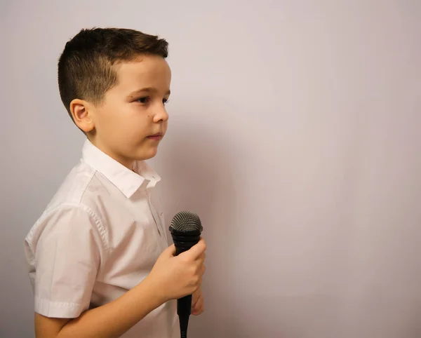 Ragazzo Con Microfono Uno Sfondo Bianco Camicia Bianca Guarda Attentamente — Foto Stock