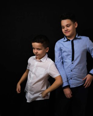 Siyah arka plandaki iki çocuk kardeştir. 9 yıl ve 12 yıl.