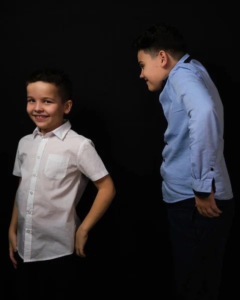 两个背景为黑色的男孩是兄长 身穿白衬衫和蓝色衬衫 笑一个大牙齿 — 图库照片