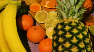 Ananas, portakal, limon, yeşil elma ve muz masada.