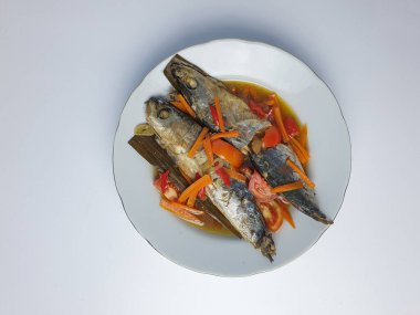 balık yemekleri ya da Endonezya 'da pindang olarak bilinir, mezeler, çorbalı balık, beyaz tabakta haşlanmış balık. beyaz arkaplanda izole edilmiş