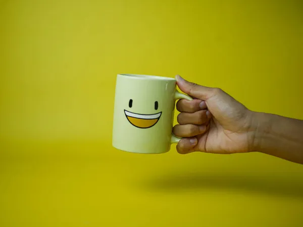 Hand Hält Gelben Kaffeebecher Mit Lächeln Emoticon Symbol Konzept Glücklich — Stockfoto