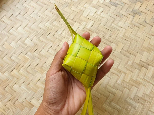 Tangan Seorang Pria Memegang Ketupat Atau Pangsit Nasi Pada Latar — Stok Foto