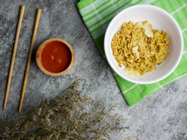 Küçük bir bambu kasesinde soslu, beyaz bir kasede kızarmış şehriye.