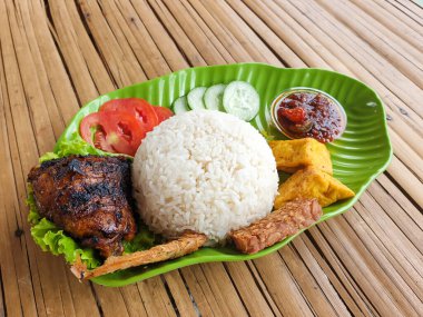 Yanında ızgara tavuk, tuzlanmış balık, tempeh ve salata ve biberli soya peyniri ile birlikte beyaz pirinç.