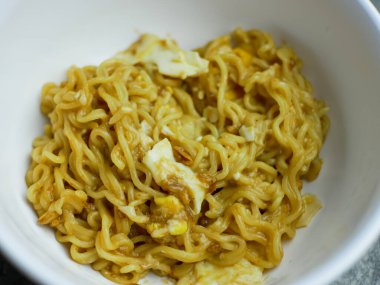 Beyaz bir kasede kızarmış erişteyi yakın.