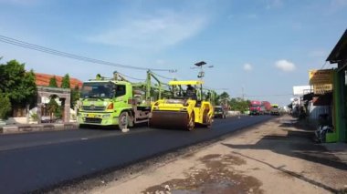 Asfalt kaldırım üzerinde çalışan iki kişilik yol silindiri. Indramayu, Batı Java, Endonezya 08 Aralık 2021