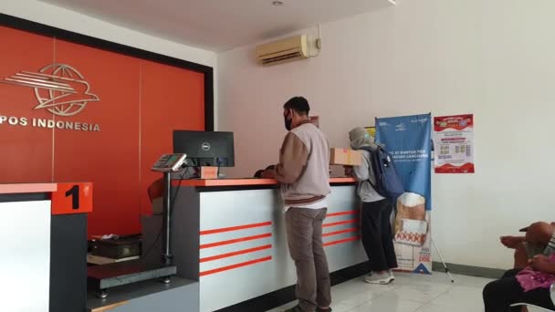 インドネシアの郵便局サービス 受付は顧客にサービスを提供しています インドネシア西ジャワ州インドラマユ2021年12月9日 — ストック動画