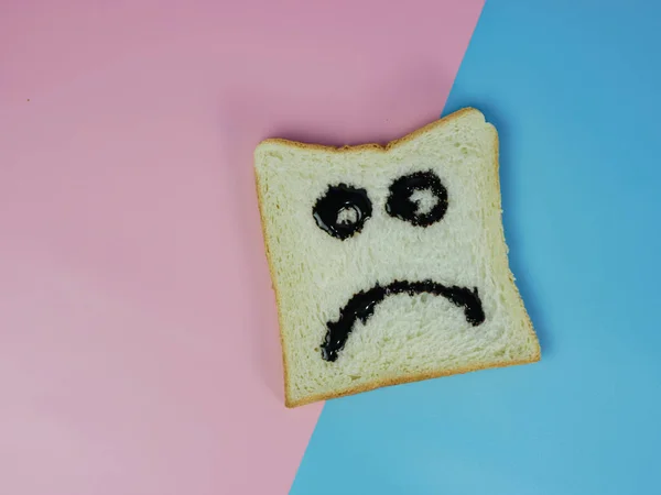 Wit Brood Met Droevige Emoticon Blauwe Roze Pastelachtergrond — Stockfoto