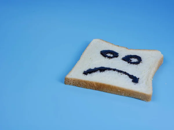 Wit Brood Met Droevige Emoticon Blauwe Pastelachtergrond — Stockfoto