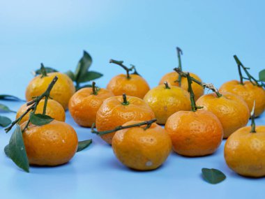 Yaprakları mavi arka planda izole edilmiş turuncu ya da turunçgiller. sağlıklı meyve