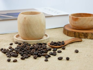 Kahveli ahşap kahve fincanı ve bulanık arkaplanlı kitap. sabah aktiviteleri