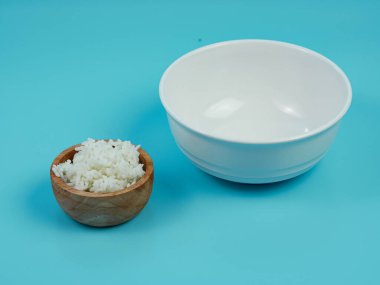 Küçük tahta bir kasede pirinç ve boş beyaz bir kase..