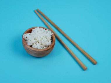 pirinç küçük tahta bir kase ve yemek çubuğunda..