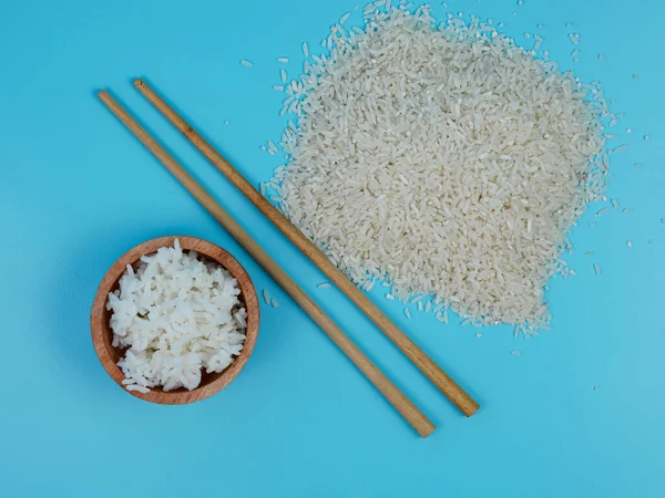 pirinç küçük tahta bir kasede yemek çubukları ve dağınık pirinçle.