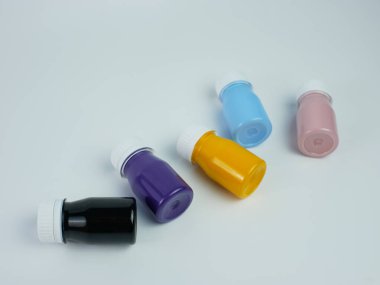 Şişede pigment reçine boyası var. Birçok renk var. Mor, pembe, mavi, turuncu ve siyah. beyaz arkaplanda izole edilmiş.
