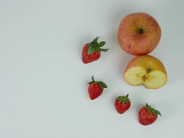 Клубника и нарезанное яблоко на белом фоне. здоровые фрукты.