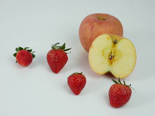 Клубника и нарезанное яблоко на белом фоне. здоровые фрукты.