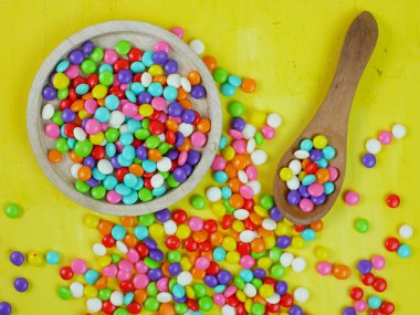 Renkli şekerlerin üst görüntüsü. Gökkuşağı şekerleri serpiştiriyor.