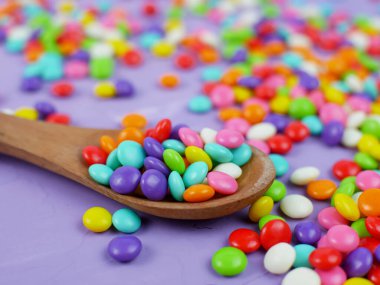 Renkli şeker. Gökkuşağı şekerleri serpiştiriyor.