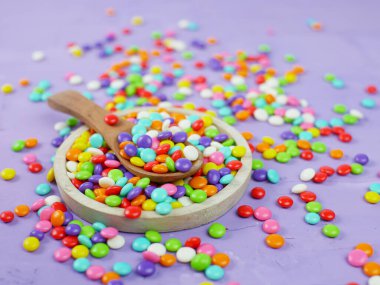 Renkli şeker. Gökkuşağı şekerleri serpiştiriyor.