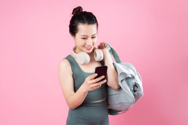 Asyalı fitness kızı portresi, pembe arka planda izole edilmiş.