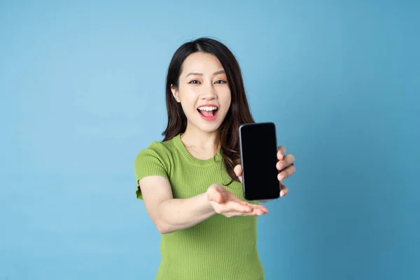 Portrait Young Asian Girl Holding Phone Isolated Blue Background — Stock Photo, Image