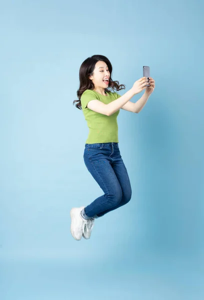 Portrait Beautiful Young Asian Girl Jumping Isolated Blue Background — Stock Photo, Image