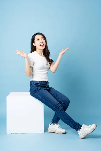 Asiática Chica Retrato Sentado Blanco Cubo Aislado Azul Fondo —  Fotos de Stock