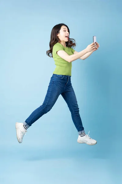 Portrait Beautiful Young Asian Girl Jumping Isolated Blue Background — Stock Photo, Image