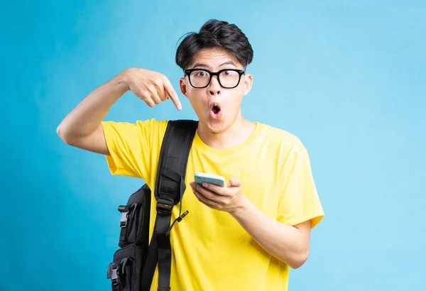 Portrait Male Student Pointing Smartphone Surprised Expression Isolated Blue Background — Stock Photo, Image