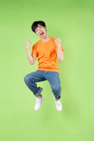 Mladý Asijský Muž Jumping Izolovaný Zeleném Pozadí — Stock fotografie
