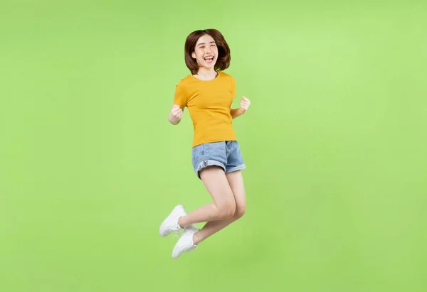 Joven Chica Asiática Saltando Sobre Fondo Verde —  Fotos de Stock
