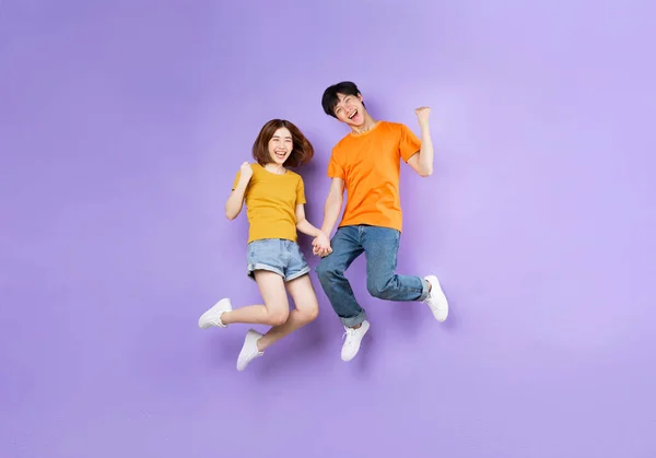 Portrait Couple Jumping Isolated Purple Background — Stock Photo, Image