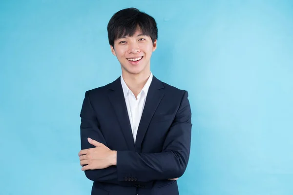 青い背景にスーツを着た若いアジア人ビジネスマンのイメージ — ストック写真