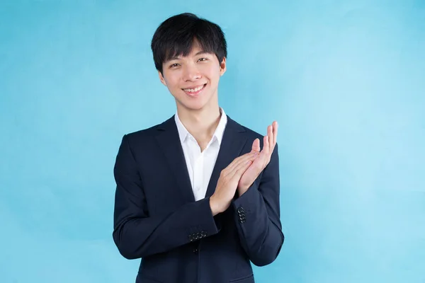 青い背景にスーツを着た若いアジア人ビジネスマンのイメージ — ストック写真