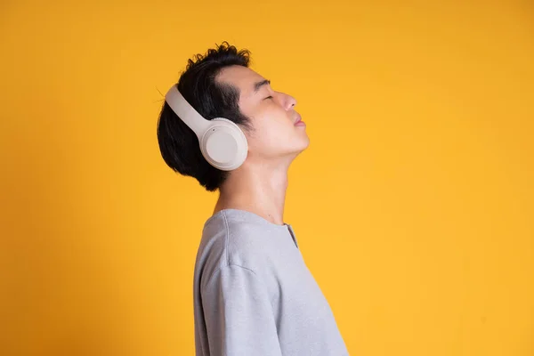Bild Asiatisk Man Lyssnar Musik Med Hörlurar Isolerad Gul Bakgrund — Stockfoto