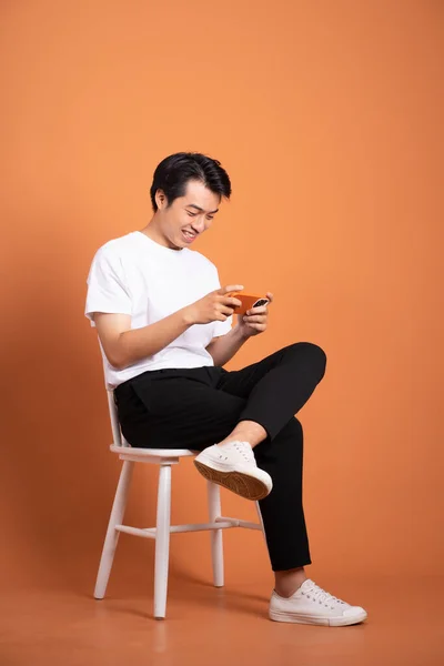 Uomo Seduto Sulla Sedia Isolato Sfondo Arancione — Foto Stock