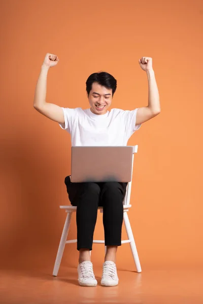 man sitting on chair  isolated on orange background