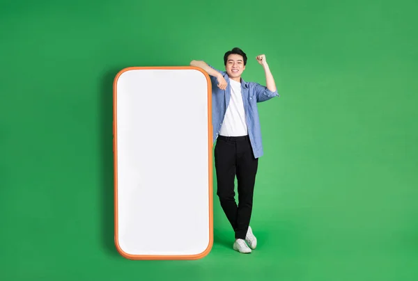 Full Body Image Asian Man Standing Next Big Smartphone Isolated — Stock Photo, Image