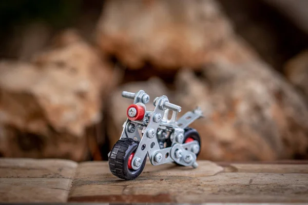 Small metal toy motorbike made from scrap metal parts.