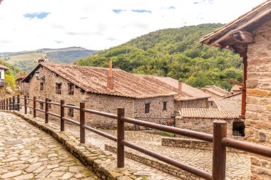 Çiçekli ve dar sokaklı resimli taş evler. 