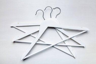 Metal kancalı beyaz ahşap elbise askıları beyaz tahta masa arkaplanı