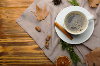 Bir fincan kahve ve yapraklar ahşap bir arka planda. Sonbahar konsepti.