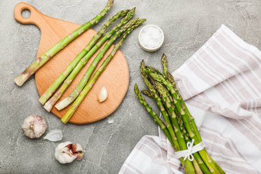 Gri arka planda pişen taze yeşil kuşkonmaz. Üst görünüm